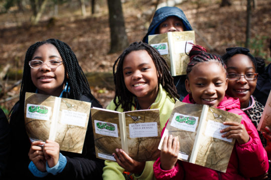 Students in the Piedmont of NC hold up their Muddy Sneakers field journals