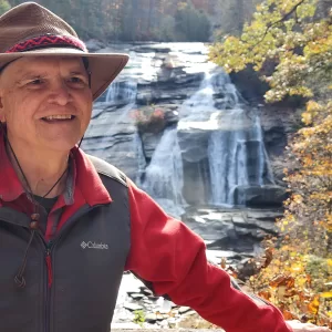 Muddy Sneakers Board Member Morris Jenkins in front of waterfall at Dupont