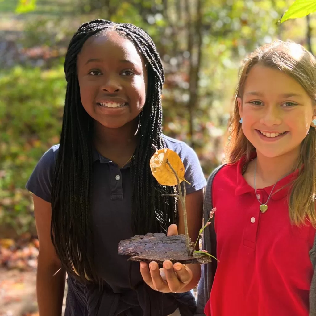 Students show the nature boat they created during Forces & Motion