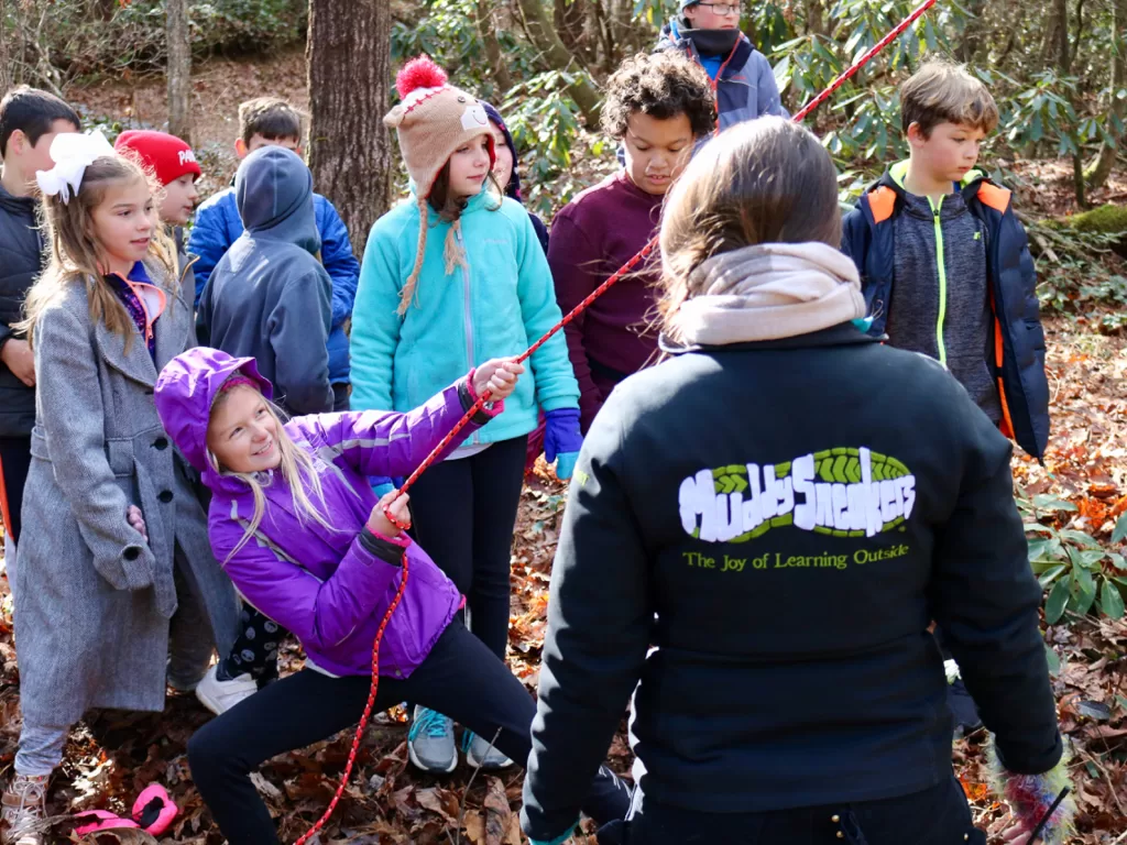 Student uses a pulley to experiment with forces and motion during a field trip.