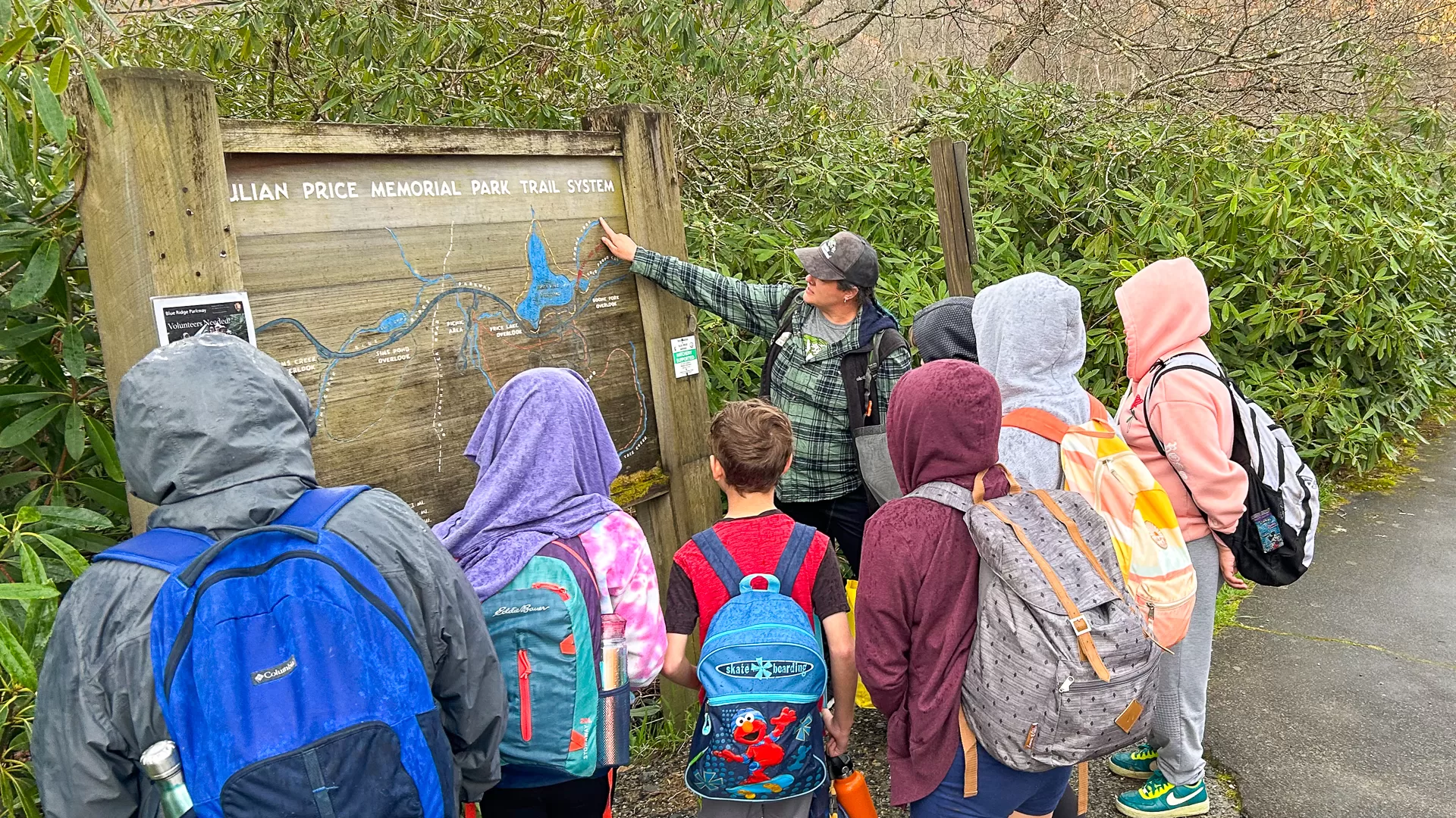 Students gather around a map of Julian Price Memorial Park Trail System before their field trip on the site.