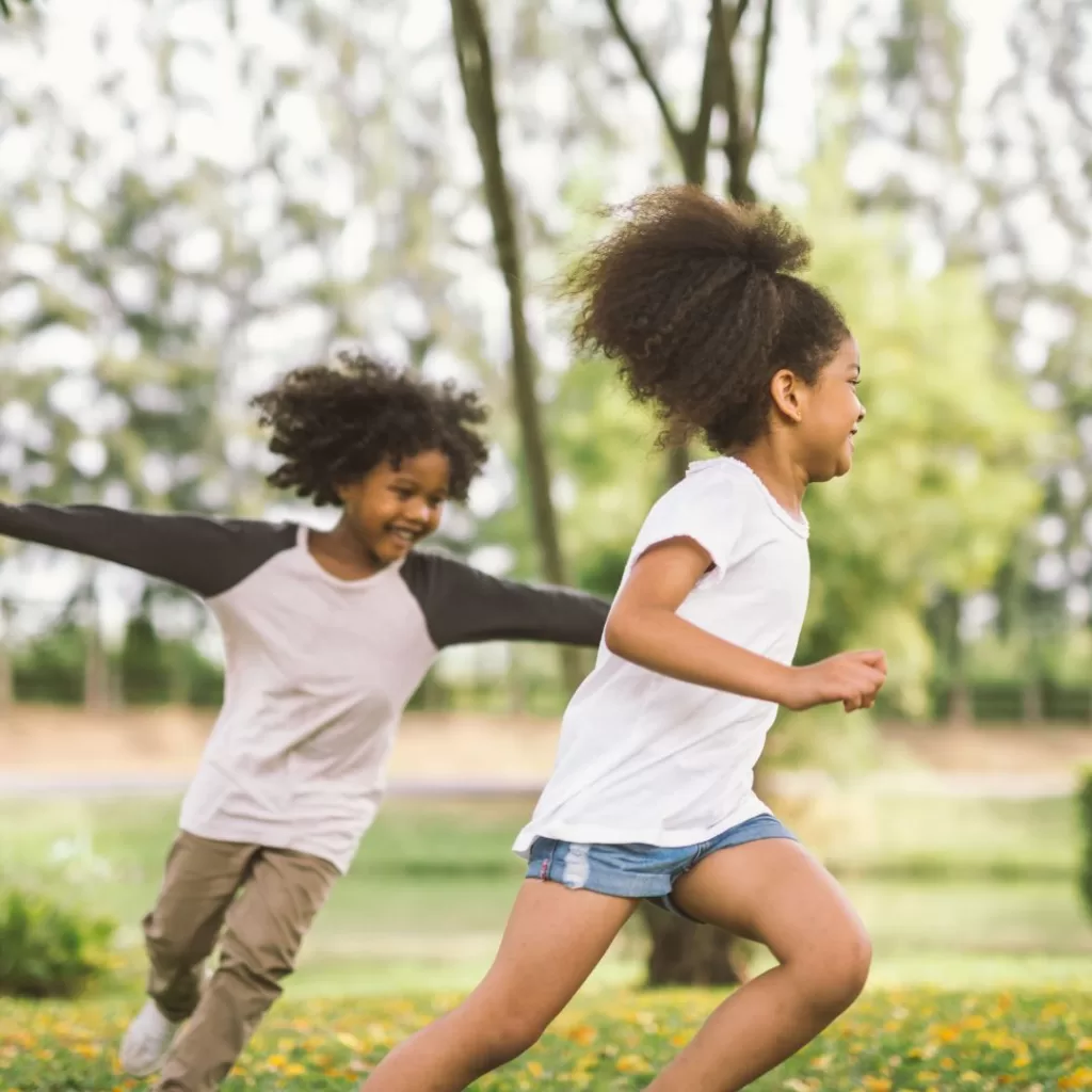 Family, featuring two siblings, spending time playing in nature.