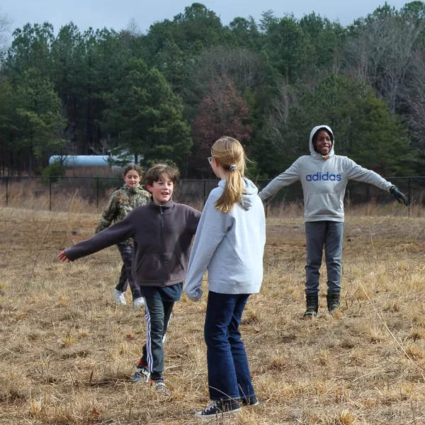 Students in a field play a game of water cycle tag